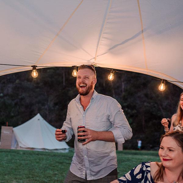 Laughing man enjoying party event under a starshade marquee
