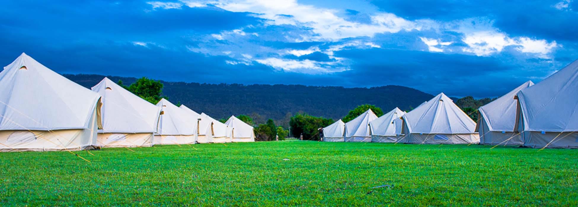 bell tents set up in two rows in a field