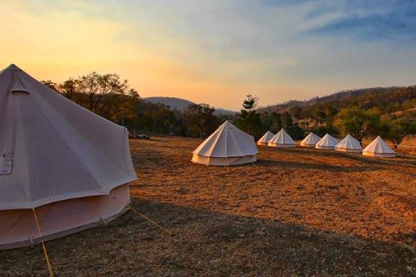 Corporate event bell tent village at sunset