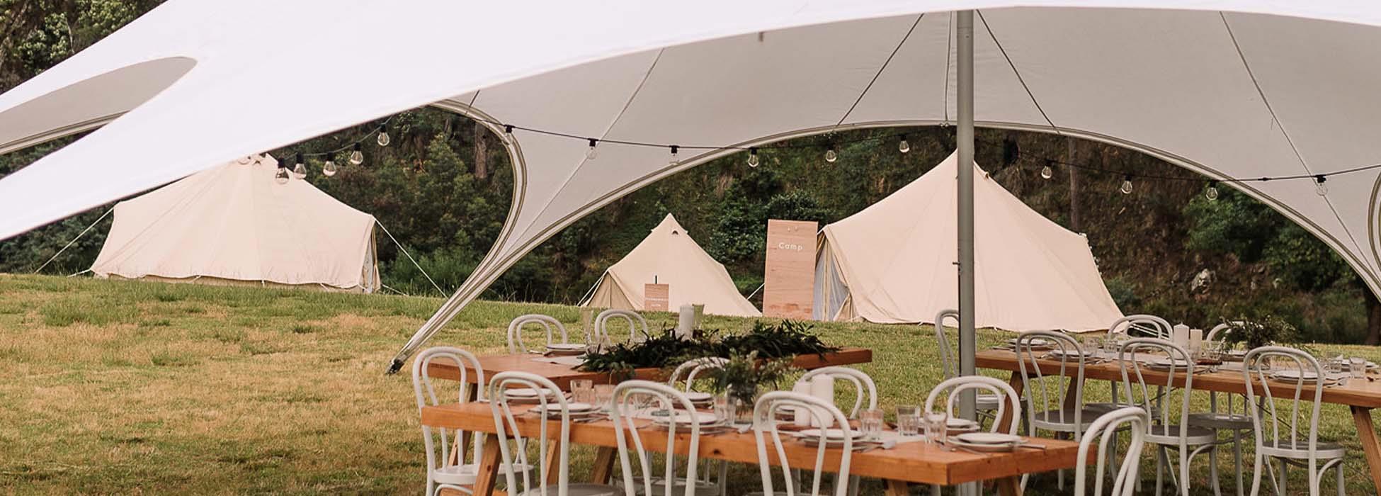 table and chairs set up for event under tent